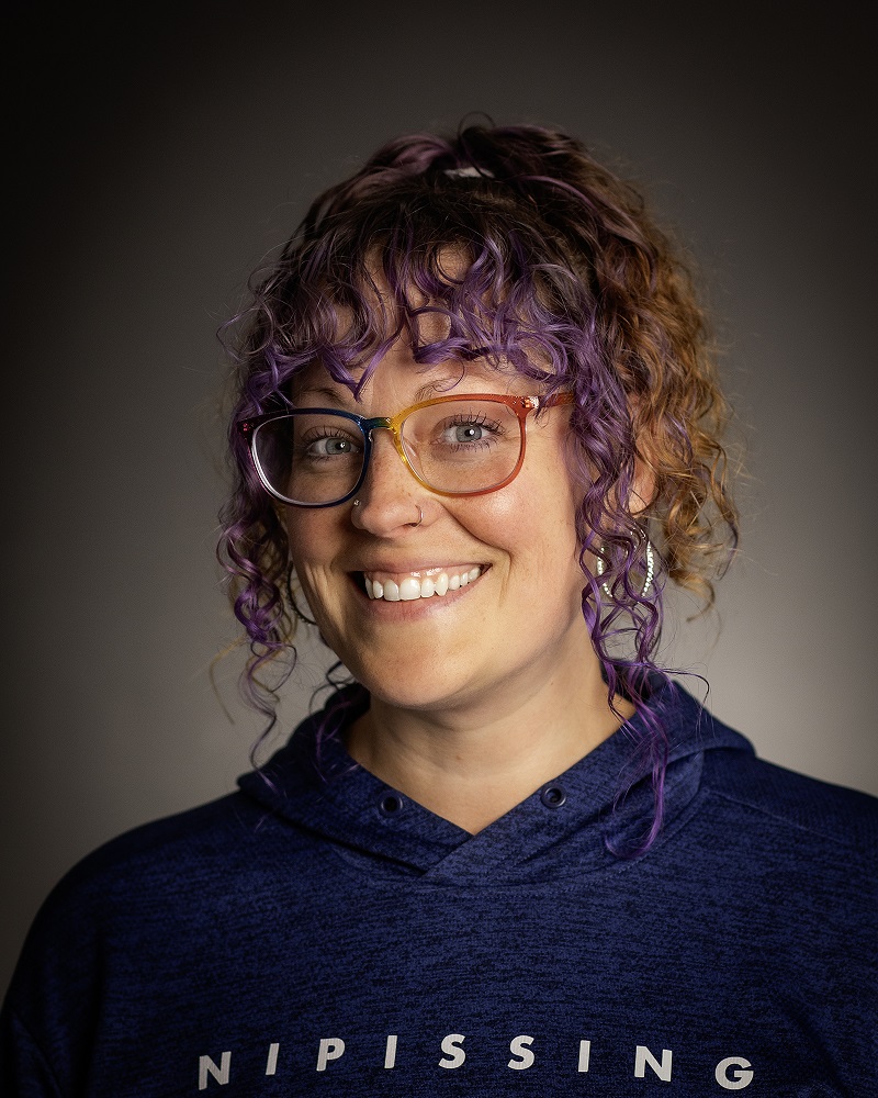 Woman in Nipissing sweater smiling.
