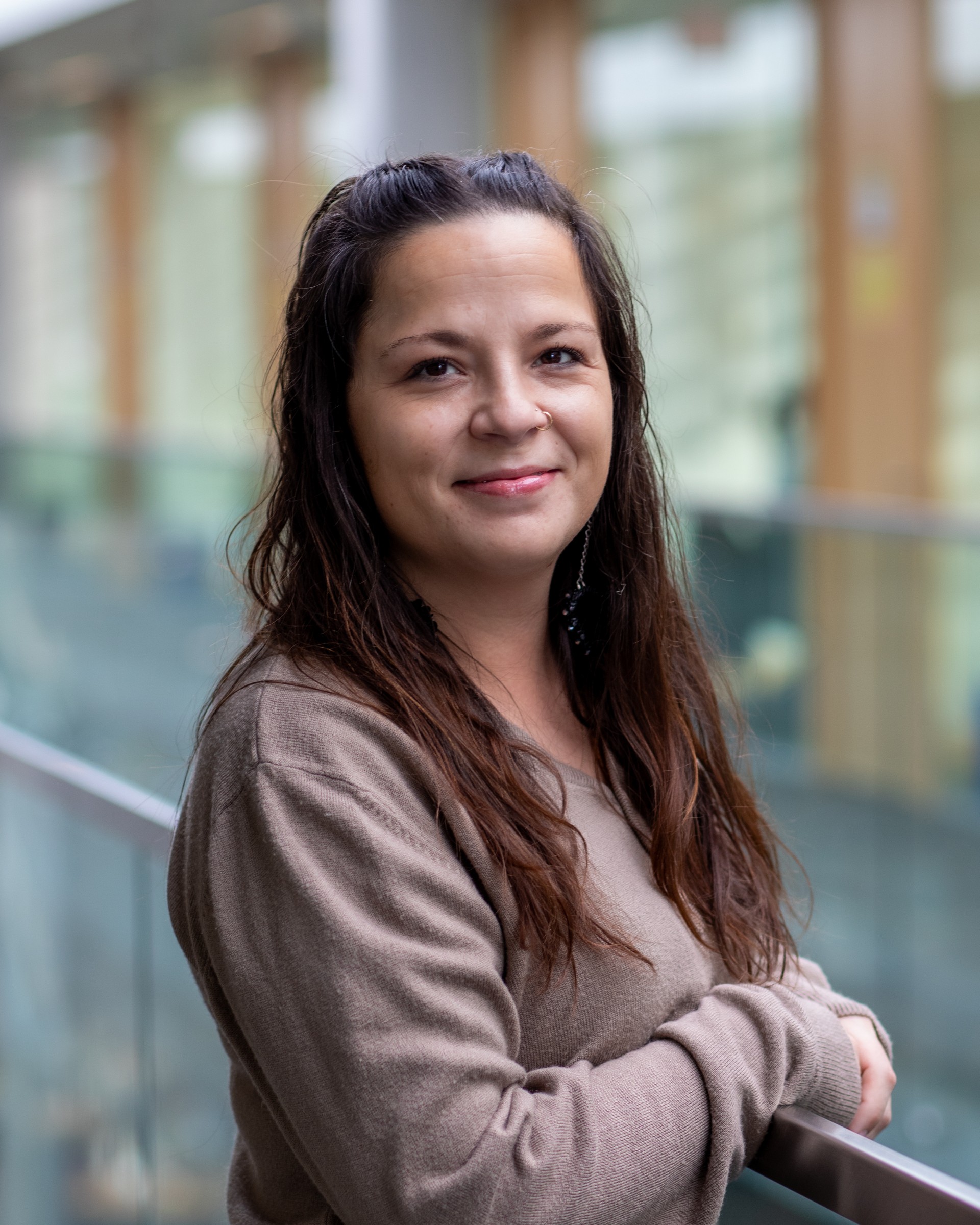 Pamela Forest, Dibaadan Wellness Coordinator smiling warmly in the library.