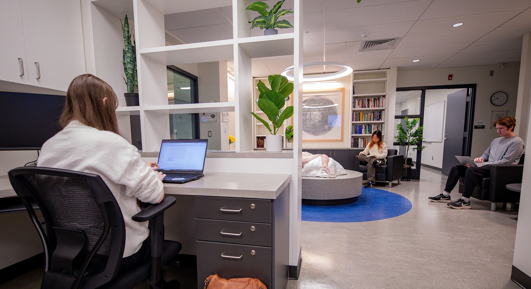 C-WAG space with 3 students doing work and reading books inside