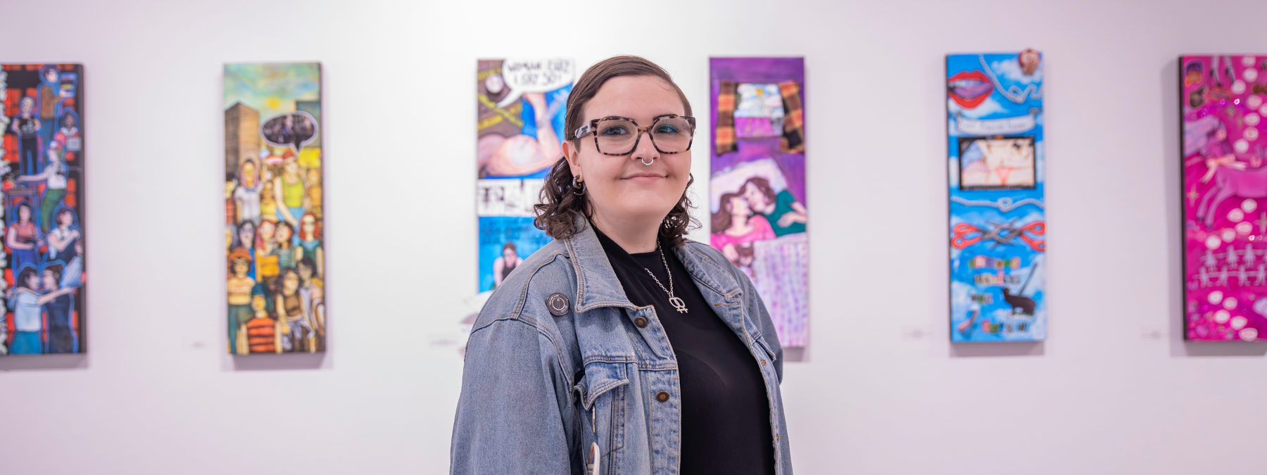 Student Emily Maville stands in front of her art installation at the gallery
