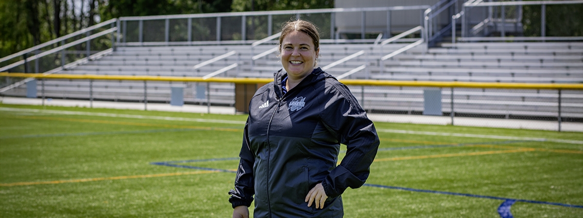 Sarah Batley stands on the Lakers turf field 