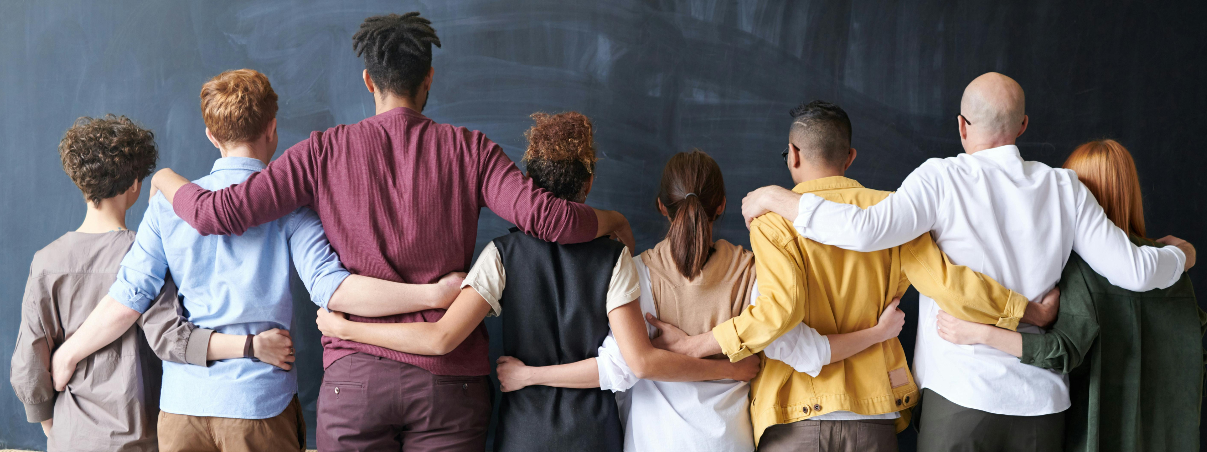 back facing group shot of everyone with their arm's around each other
