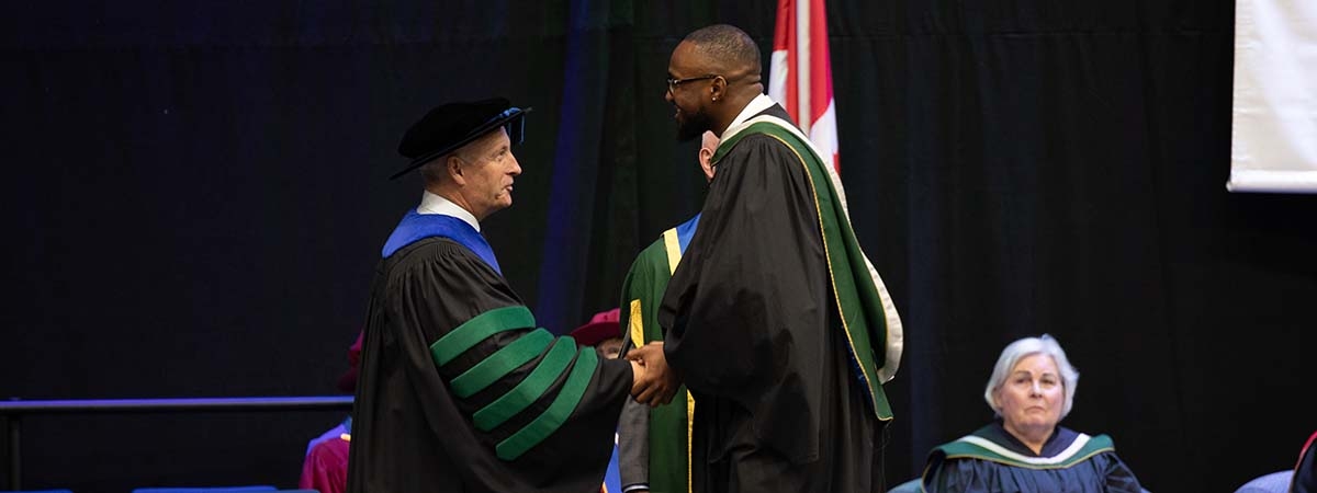 Dr Wamsley congratulates new Nipissing graduate