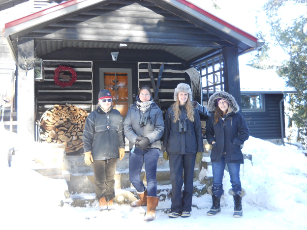 Photo of people standing in the snow in front of a building