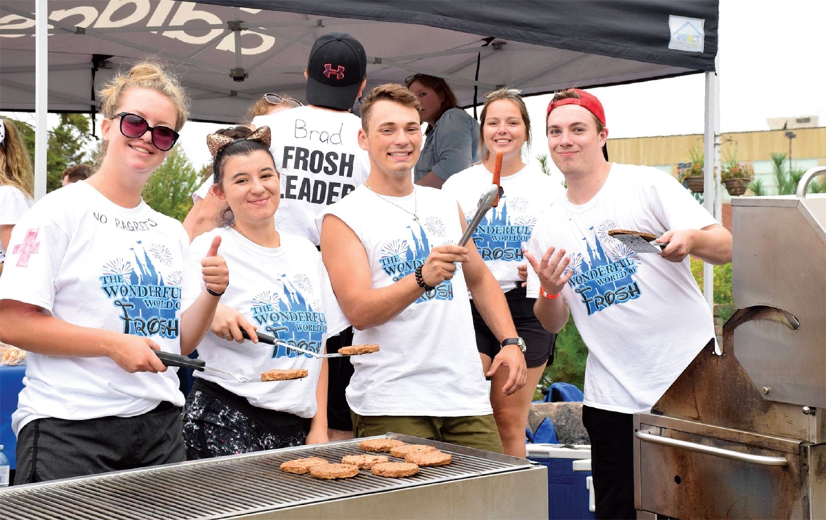 a group of students barbecuing and posing for picture