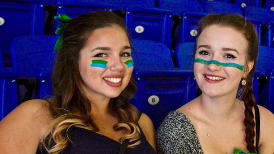 Two people at Hockey game stands