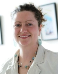 A woman in white top against a light interior background
