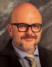 Shawn Darby from the shoulder up in front of a grey textured background