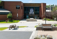Spring photo of the main doors and plants around Nipissing University on a sunny day