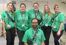 NU student group photo at the Nursing games, standing in a hospital simulation setting. 