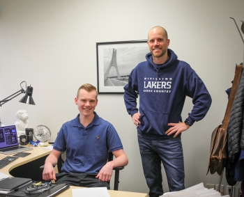 Graydon and student Kyle, sit at Graydon's desk
