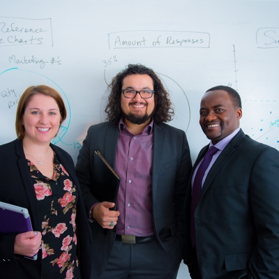Two students standing with professor
