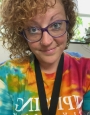 Woman in tie dye shirt smiling.