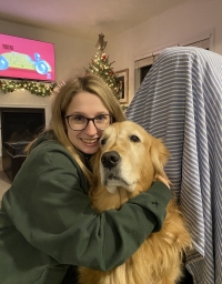  Sarah Pecoskie Schweir hugs a golden retriever. 